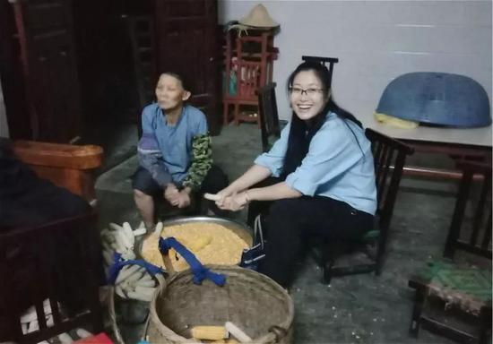  黄文秀到村民家走访，主动帮村民干活。（资料照片）