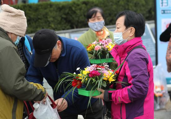 抱着鲜花的祭扫市民。摄影/新京报记者&nbsp;王贵彬