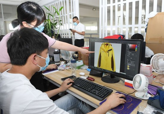  在浙江省台州市三门县的一家户外用品企业，工作人员在讨论一款冲锋衣的设计（2022年6月14日摄）。新华社记者 翁忻旸 摄