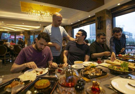 在义乌经营餐厅的约旦老板穆罕奈德（左二）与朋友们聊天，他2002年来到义乌创业，并在此安家。