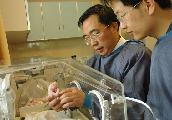  大熊猫专家张和民（左）与大熊猫宝宝在一起（资料照片）。新华社发