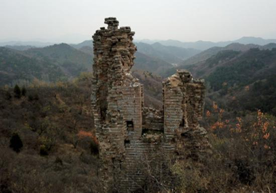  三面墙已经坍塌，仅剩下砖头参差、孑然独立的一面墙，整体基础下沉、墙体严重开裂，岌岌可危的北京市密云区古北口地区蟠龙山长城的306号敌台。新华社记者罗晓光摄