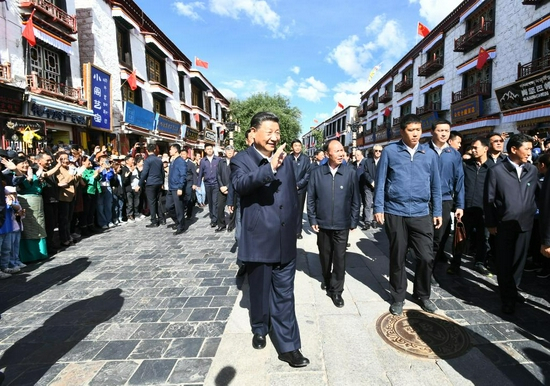 7月22日下午，习近平在考察位于拉萨市老城区的八廓街时，向各族群众挥手致意。新华社记者 谢环驰 摄