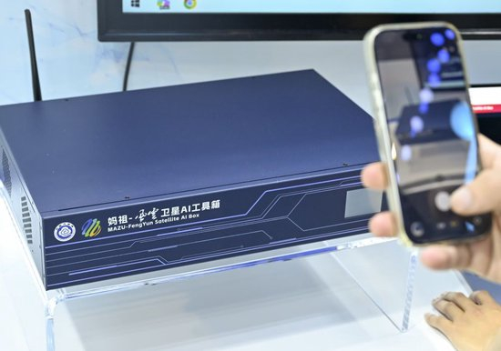 2026年7月19日，参观者在上海举行的2026世界人工智能大会的中国气象局展台拍摄展品&ldquo;妈祖&rdquo;风云卫星AI工具箱。新华社记者 陈浩明 摄