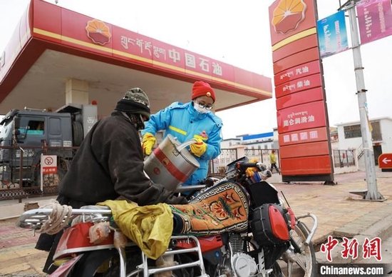双湖加油站第六任站经理次旦巴宗正在为顾客加油。中国石油供图