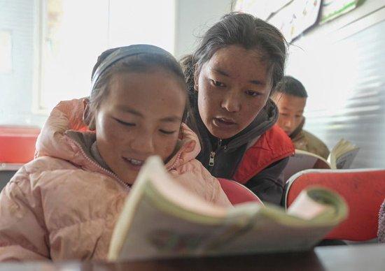 西藏大学学生措姆在西藏定日县曲洛乡热木青村地震安置点为学生辅导作业(2025年1月25日摄)。新华社记者 晋美多吉 摄