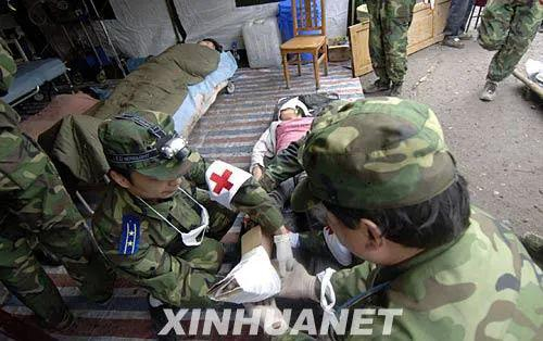 2008年5月14日，解放军某部医护人员在北川地震灾区救助受伤群众。图源：赵颖全|新华社