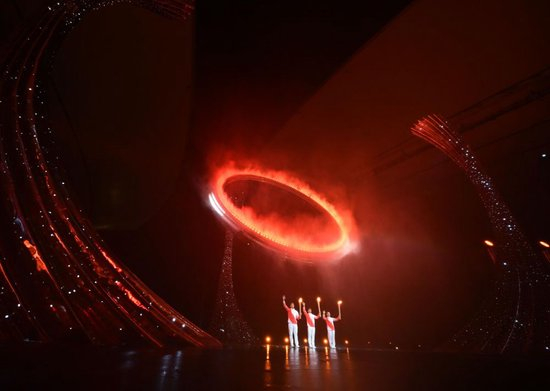 2025年11月9日，第十五届全国运动会开幕式在广东奥林匹克体育中心举行。这是火炬手苏炳添（中）、张家朗（左）、李祎点燃主火炬后向观众致意。新华社记者 肖艺九 摄