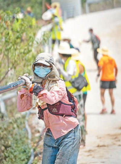 志愿者在铺设输水管道。　新华社记者 朱高祥摄