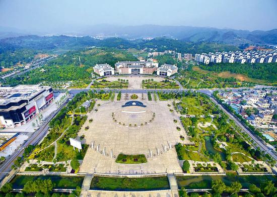 湖南省汝城县举债修建的爱莲广场，仅6棵银杏树就花了285万元，8根图腾石柱花了120万元。与广场相对的是县委县政府的办公大楼。图/《中国纪检监察报》