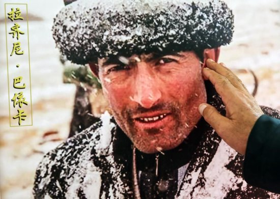 2023年9月4日，巴依卡老人抚摸儿子拉齐尼的照片。新华社记者 兰红光 摄