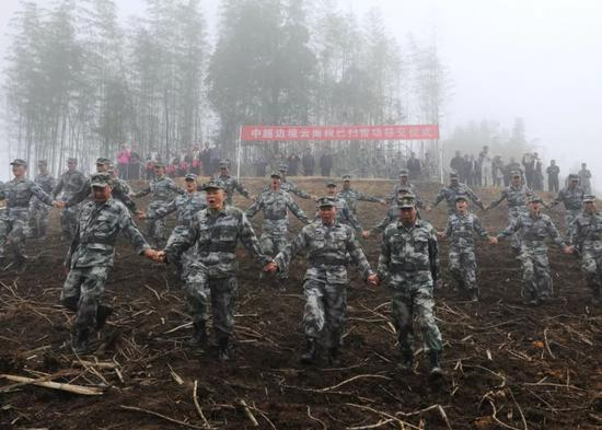 　南部战区陆军云南扫雷大队官兵在云南省麻栗坡县老山西侧坝子雷场手拉着手徒步验收已扫雷场。（彭希&nbsp; 摄）