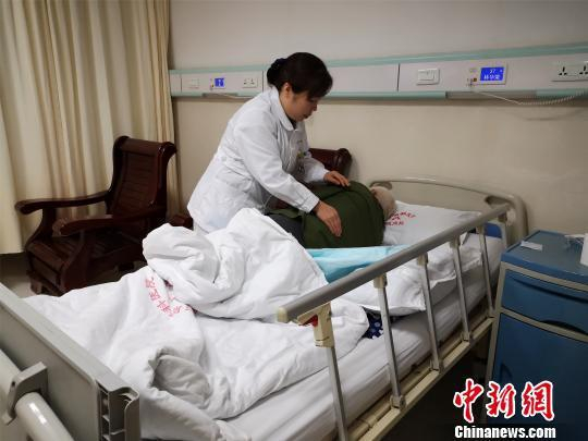 资料图：一名精神科护士帮患者拍背舒缓。　林馨 摄