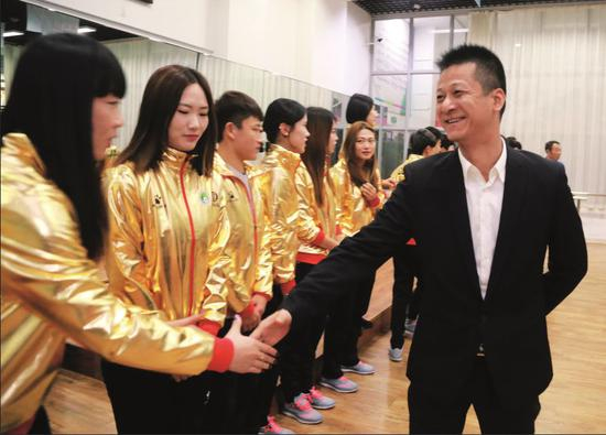  2016年11月25日，辽宁省大连市，束昱辉和大连权健女足教练及队员见面。