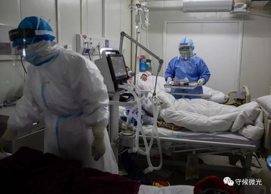 　　2月21日，武汉火神山医院感染八科，医护人员在病床前询问患者的情况。中青报·中青网记者李峥苨/摄