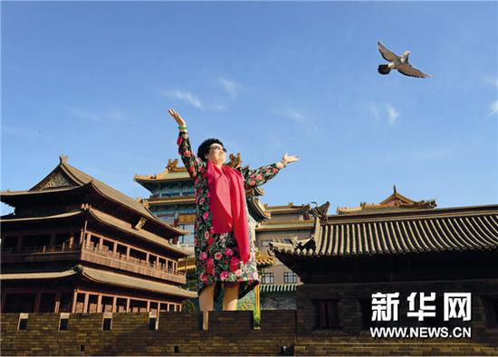 图片说明：陈丽华在“古城门”上放飞梦想