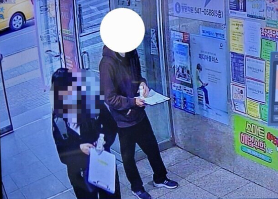 　·兼职大学生（右）向路过的学生发毒品饮料。