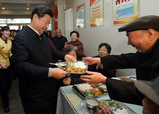2013年2月4日，习近平总书记来到甘肃兰州一家养老餐厅，端起一盘热气腾腾的饭菜，送到一位老人面前。（图片来源：央视网）