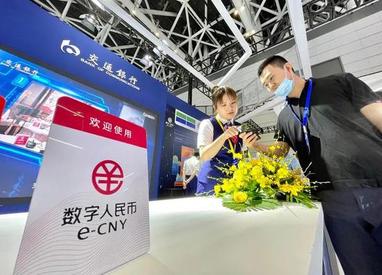 （工作人员指导市民使用数字人民币。记者 王旭东 摄）