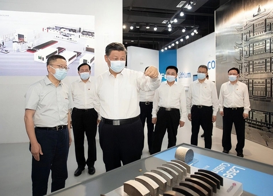 （2022年6月28日，习近平总书记考察武汉华工激光，拿起一片由激光科技精雕的微型“黄鹤楼”。）