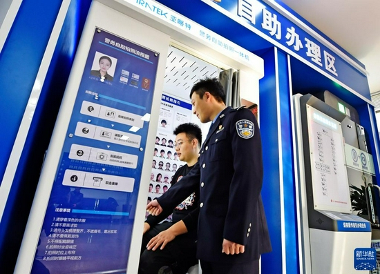 在辽宁省本溪市公安局北地派出所民警指导下，市民通过自助体检机完成机动车驾驶人检测项目（12月10日摄）。新华社发