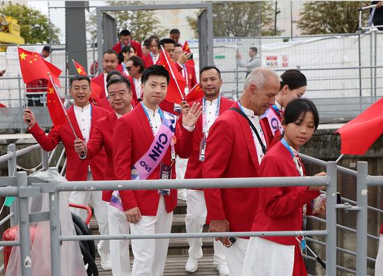 当地时间7月26日，中国体育代表团乒乓球选手马龙（前左三）在开幕式前登船。（图片来源：新华社记者 曹灿 摄）