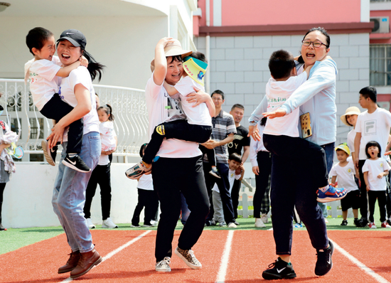  ▲&nbsp;5月30日，江苏省连云港市海州区一所幼儿园，家长与小朋友们一起进行亲子趣味游戏 王春摄 / 本刊
