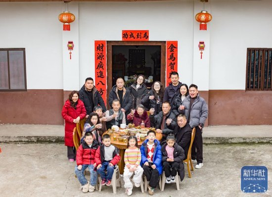  ↑ 2月16日，在四川省南充市顺庆区清平村，村民陈俊尧一家祖孙四代吃团年饭。新华社发（彭珉翔 摄）