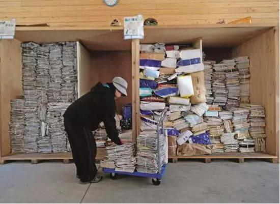 　　3月14日，在日本德岛县上胜町的垃圾处理中心，一名工人整理废旧报纸和杂志。上胜町是日本四国岛德岛县的一个小镇，在日本国内以垃圾分类细致而著称，分类达到45 类。图/视觉中国