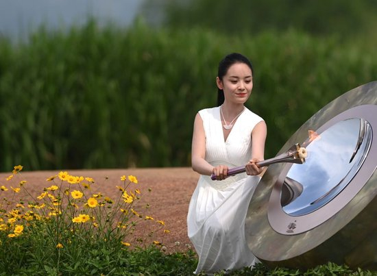  2023年6月15日，杭州亚运会火种采集仪式在浙江杭州良渚古城遗址公园举行。图为采火使者点燃采火棒。新华社记者 黄宗治 摄