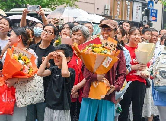 ▲2024年6月10日，在杭州第十四中学考点门外，考生家长和亲人用鲜花和拥抱，迎接走出考场的孩子。（人民视觉/图）