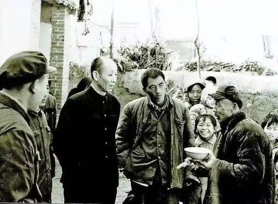  周振兴（左二）与农民交谈。图源：菏泽日报