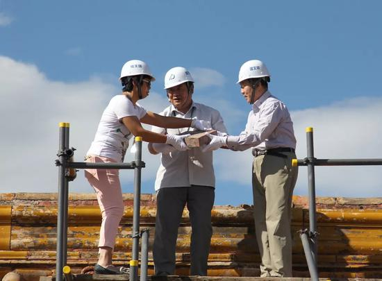  故宫博物院院长单霁翔（中）与前院长郑欣淼（右）将宝匣取出，交给故宫古建部副研究馆员徐超英（左）。