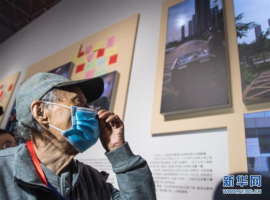 曾在疫情期间因一张“陪你去看夕阳”的照片走红网络的新冠肺炎康复患者王欣在武汉举行的抗击新冠肺炎疫情专题展览上参观（2020年10月15日摄）。新华社记者 肖艺九 摄