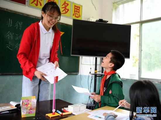 在贵州省毕节市百里杜鹃管理区大水乡大石村大石希望小学，华中农业大学“本禹志愿服务队”第十六届研究生支教团成员陈倩雯在和学生交流（2020年9月9日摄）。新华社发（李华 摄）