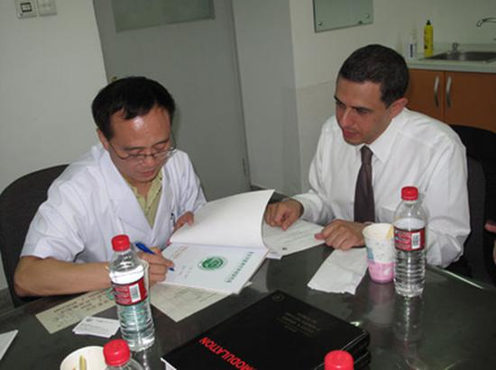 ▲2009-9-18-美国运动障碍病专家Ali-Rezai教授来访，李勇杰教授签名赠书。