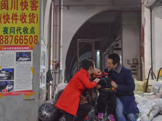 黄爱华带着小聪聪到长途车上车点送黄海龙。上车之前，一家人说说笑笑。