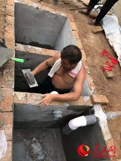 秦岭山脚下的向阳村村民正在修建三格化粪池。人民网记者 申亚欣摄