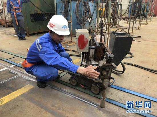 陈庆城演示埋伏自动焊。新华网发（李夏摄）
