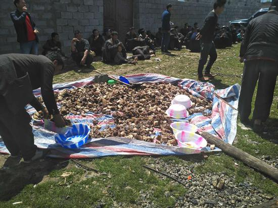 参加赤尔丧礼的人聚在草坪吃坨坨肉。