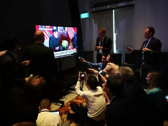 各国记者们围在新闻中心电视前记录金特会的历史时刻