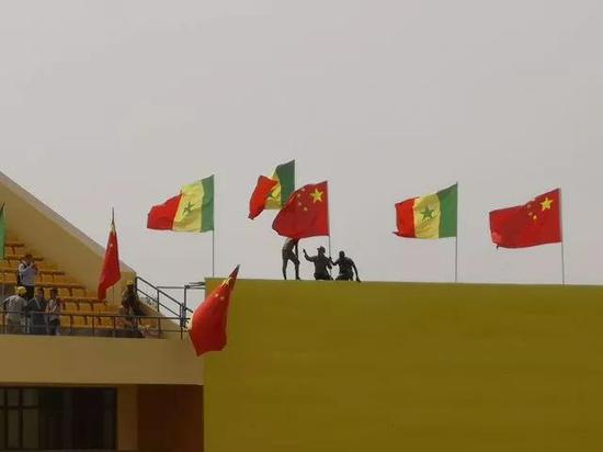 位于达喀尔近郊的塞内加尔竞技摔跤场，工作人员布置国旗，迎接习近平主席到来。（新华社记者廖宇杰摄）