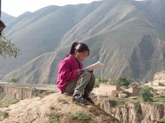 ▷马百娟在山坡上读书