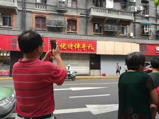 事发后，奇遇城堡被木板钉住。8月14日早上有路人在此拍照。新京报记者王双兴摄