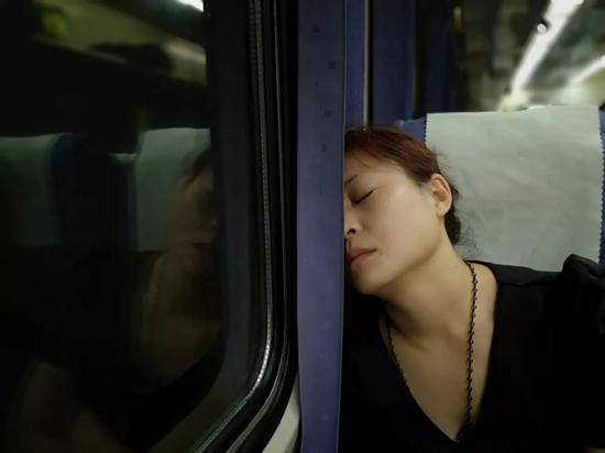　　关桂侠在承德前往石家庄的火车上睡着了。刑满释放后，她每个月都要来石家庄几趟，来给还在服刑的妈妈和姐姐送东西。新京报记者段睿超 摄