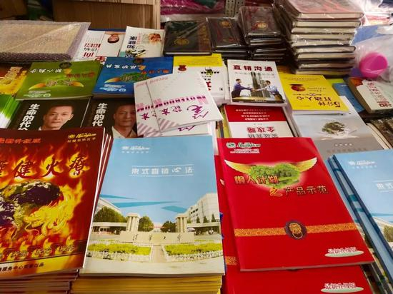  小饭馆的隔壁，是一家杂货铺，杂货铺的老板娘也自称是权健的会员。店里有各种权健的产品、火疗毛巾、以及权健和直销的宣传资料。