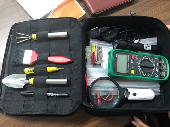 火调员的工具包有了越来越多的高科技元素，但顾耀耀说，最实用的还是钉耙和刷子。 殷梦昊 摄