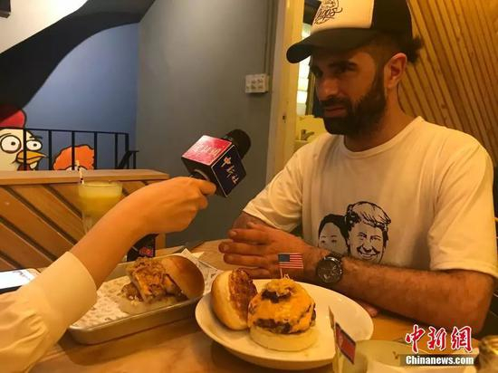 当地时间2月25日，河内市中心一家餐厅推出两款以金正恩、特朗普为主题的汉堡，招徕顾客。图为汉堡设计者之一接受中新社、中新网采访。中新网记者孟湘君 摄