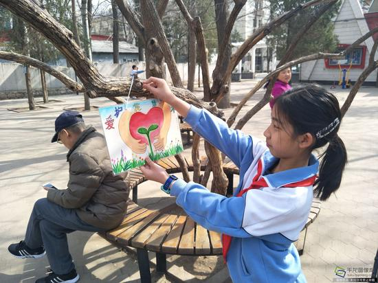 朝师附小绘制标语牌美化社区。学校供图。