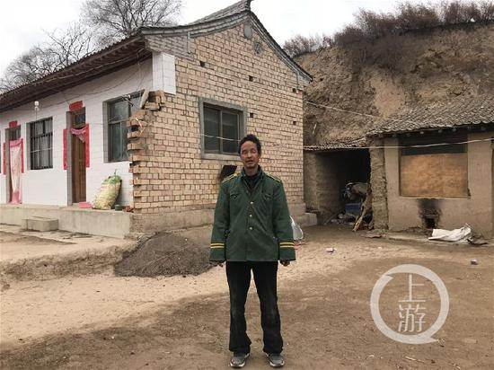▲48岁的张春银和身后在政府资助下去年才修好的两间砖房。摄影/上游新闻记者 范永松